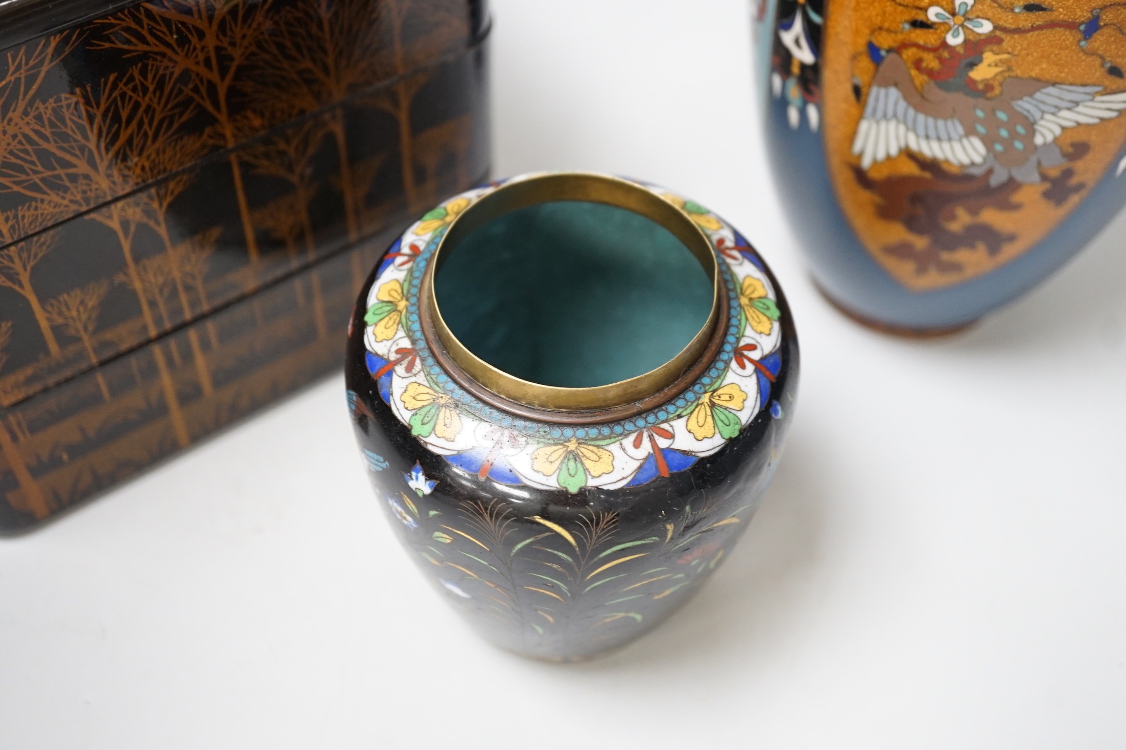 A large Japanese cloisonné enamel vase, 30.5cm high, a similar jar and cover and a Japanese lacquered tiered box with 3-4 drawers. Tree design in gold lacquer.